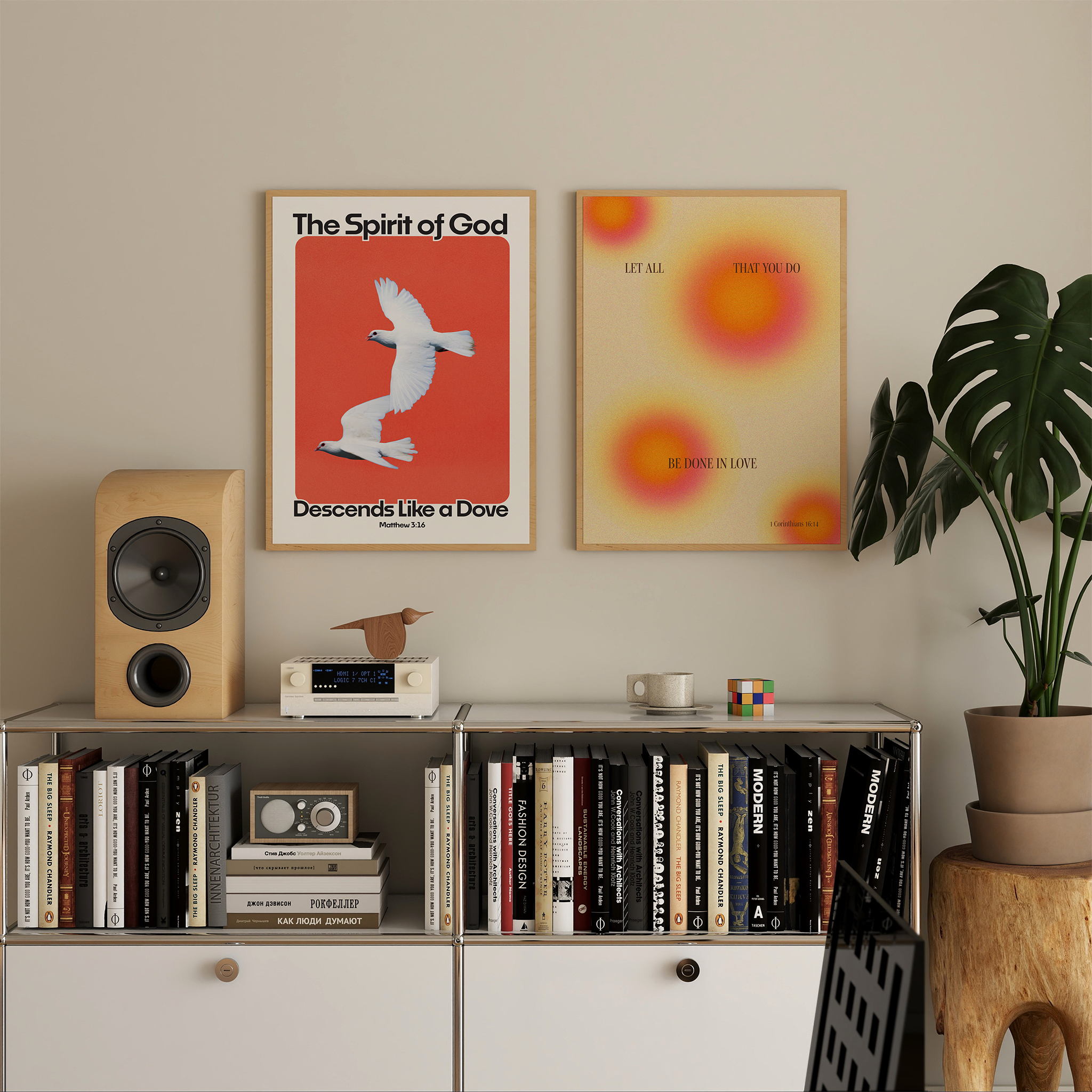 Two framed wall art prints hang above a white cabinet in a styled room. The left print has a red background with two white doves and the text 'The Spirit of God Descends Like a Dove.